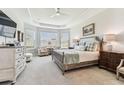 Bright main bedroom with tray ceiling, bay windows, and comfortable furnishings at 4574 Freccia Loop, Wesley Chapel, FL 33543