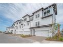 New construction townhomes featuring a white exterior with attached garages and well manicured landscaping at 5351 Bridge St # 99, Tampa, FL 33611