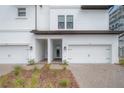 Exterior view of townhomes featuring attached garages, a brick paved driveway and landscaping at 5351 Bridge St # 99, Tampa, FL 33611