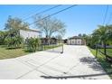 Long driveway leading to a charming home and garage with a mix of stone and metal at 5560 Frances Ave, New Port Richey, FL 34653