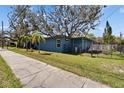 Charming one story home with mature landscaping, sidewalk, and a fenced yard at 725 Philippe Pkwy, Safety Harbor, FL 34695