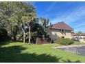 Well-kept condo exterior with green lawn and lush trees under blue skies at 730 S Village N Dr # 101, St Petersburg, FL 33716