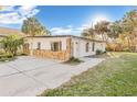 Side angle of home with stone accents, showing a large driveway and well-kept lawn at 7301 S Swoope St, Tampa, FL 33616