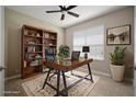 Home office featuring a ceiling fan, a window providing natural light, and built-in bookshelf at 7326 Blue Beech Dr, Riverview, FL 33578