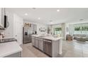 Modern kitchen boasts stainless steel appliances, a center island, and an open floor plan at 7796 Wheat Stone Dr, Zephyrhills, FL 33540