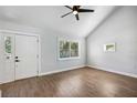 Bright living room featuring wood floors, vaulted ceilings, a ceiling fan, and lots of natural light at 10847 Bounty St, New Port Richey, FL 34654