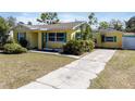 Quaint yellow house with vibrant blue shutters, a cozy exterior with well-maintained lawn at 1223 Union St, Clearwater, FL 33755