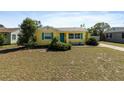 Lovely yellow home featuring a bright blue door and shutters, enhanced curb appeal at 1223 Union St, Clearwater, FL 33755