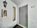 Exterior front door with secure entry and building details at 1337 Pine Ridge E Cir # D2, Tarpon Springs, FL 34688