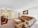 Comfortable living room with fan, plush seating, and view into kitchen at 1337 Pine Ridge E Cir # D2, Tarpon Springs, FL 34688