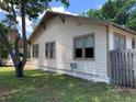 Side exterior view of the home featuring new roof, lush lawn, and ample windows at 1801 12Th N St, St Petersburg, FL 33704