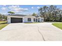 This single-story home features a two-car garage, large driveway and eye-catching, arched window accents at 18214 Ozark Dr, Hudson, FL 34667