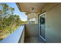 Cozy condo balcony with views of lush greenery, providing a peaceful outdoor space at 2019 Utopian W Dr # 310, Clearwater, FL 33763