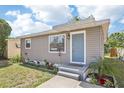 Cozy home featuring neutral siding, a light blue front door, and well-maintained front yard landscaping at 2726 25Th N Ave, St Petersburg, FL 33713