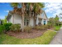 Lovely home exterior with mature palm trees, lush landscaping, and a neatly kept lawn at 4127 Broad Porch Run, Land O Lakes, FL 34638