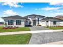 Striking white home featuring well-maintained landscaping and a grey brick driveway at 4135 Epic Cv, Land O Lakes, FL 34638