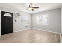 Bright living room with light wood floors, ceiling fan, and black front door at 4218 2Nd S Ave, St Petersburg, FL 33711