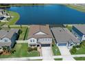 Aerial view of home with a large backyard, pool, and access to a beautiful lake at 8780 Flourish Dr, Land O Lakes, FL 34637