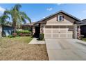 Charming home with a two-car garage, stone accents, and lush landscaping at 12220 Legacy Bright St, Riverview, FL 33578
