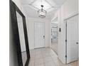 Bright foyer with tile flooring, decorative lighting fixture, and large mirror creating an open and inviting space at 12377 Streambed Dr, Riverview, FL 33579