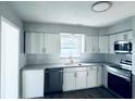 Well-lit kitchen with white cabinets, subway tile backsplash, granite countertops, and stainless steel appliances at 1409 Franklin St, Clearwater, FL 33756