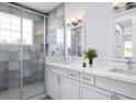 Bright bathroom featuring double vanity with modern fixtures, a large glass shower, and neutral tile work at 15513 Aldama Cir, Port Charlotte, FL 33981