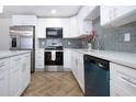 Modern kitchen with stainless appliances, bright cabinets, and herringbone flooring at 1902 Andover St # 198, Sun City Center, FL 33573