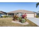 Charming single-story home features a manicured lawn, mature landscaping, and a two-car garage at 2335 E Del Webb Blvd, Sun City Center, FL 33573