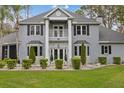 Charming two-story home featuring a balcony, bay windows, manicured lawn, and a beautifully landscaped front yard at 27625 Lincoln Pl, Wesley Chapel, FL 33544