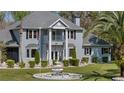 Beautiful two-story home with landscaped yard, featuring a fountain, bay windows and a second story front-facing balcony at 27625 Lincoln Pl, Wesley Chapel, FL 33544