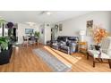Living room with hardwood floors, ceiling fan, plants, and a comfortable black leather sofa at 4152 56Th N Way # 614, Kenneth City, FL 33709