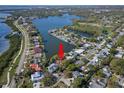 Aerial view of a waterfront community with mature landscaping, situated on a peninsula near a lake and neighborhood park at 550 7Th S St, Safety Harbor, FL 34695