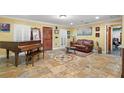 Cozy living room showcases tile floors, natural lighting, a piano, a leather couch, and classic architecture details at 550 7Th S St, Safety Harbor, FL 34695