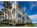 Exterior view of building showing balconies, landscaping and impact windows at 7645 Sun Island S Dr # 201, South Pasadena, FL 33707