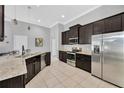 Spacious kitchen featuring dark cabinets, stainless steel appliances, tile floors, and granite countertops at 867 Vino Verde Cir, Brandon, FL 33511