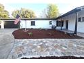 View of the front yard featuring a brick pathway leading to the front door and a manicured lawn at 9308 Pinero St, Spring Hill, FL 34608