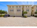 A row of three-story townhomes with garages and brick paver driveways at 1076 Paseo Del Rio Ne, St Petersburg, FL 33702