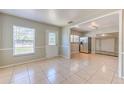 Bright living room with tile flooring, large windows, and an open view to the kitchen and dining area at 10928 N 15Th St, Tampa, FL 33612