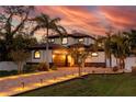 Stunning two-story home with brick driveway, lush landscaping, and a serene ambiance at twilight at 11215 53Rd N Ave, St Petersburg, FL 33708