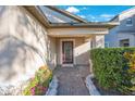 A close-up view of the house's entryway, featuring a decorative glass front door and neat landscaping at 12523 Longstone Ct, New Port Richey, FL 34655
