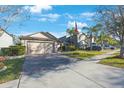 Home with lush landscaping, brick driveway, and flag pole on a sunny day with clear blue skies at 12523 Longstone Ct, New Port Richey, FL 34655