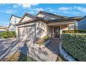 Well-maintained home with brick-paved walkway, stone-lined flowerbeds, and an attached two-car garage at 12523 Longstone Ct, New Port Richey, FL 34655