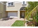 Charming home exterior with a well-manicured lawn, two-car garage, and covered entryway at 156 117Th Ave, Treasure Island, FL 33706