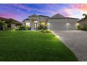 Charming home with a well-kept lawn, paver driveway, and a spacious three-car garage, captured at twilight at 15909 39Th E Gln, Parrish, FL 34219