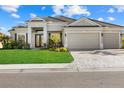 Beautiful home featuring a well-manicured lawn, paver driveway, and a spacious three-car garage at 15909 39Th E Gln, Parrish, FL 34219
