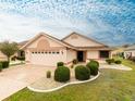 Charming single-story home with a well-manicured lawn, a two-car garage, and a beautifully patterned driveway at 1603 E Del Webb Blvd, Sun City Center, FL 33573