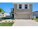 Charming two-story home with a two-car garage, well-maintained lawn and manicured landscaping at 16614 Mosaic Oar Dr, Wimauma, FL 33598