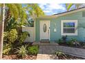 Close-up of the inviting front entrance, featuring a white door, paver walkway, and lush greenery at 4750 Burlington N Ave, St Petersburg, FL 33713