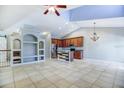 Open-concept living area featuring high ceilings, tile floors, and a modern kitchen with stainless steel appliances at 6036 Fishhawk Crossing Blvd, Lithia, FL 33547