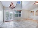 Bright living room boasts high ceilings, tile flooring, and French doors leading to outdoor space at 6036 Fishhawk Crossing Blvd, Lithia, FL 33547